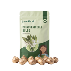 A stand-up pouch of Paankhuri Chincherinchee Bulbs on a white background, with several raw white onions arranged in front of the package.
